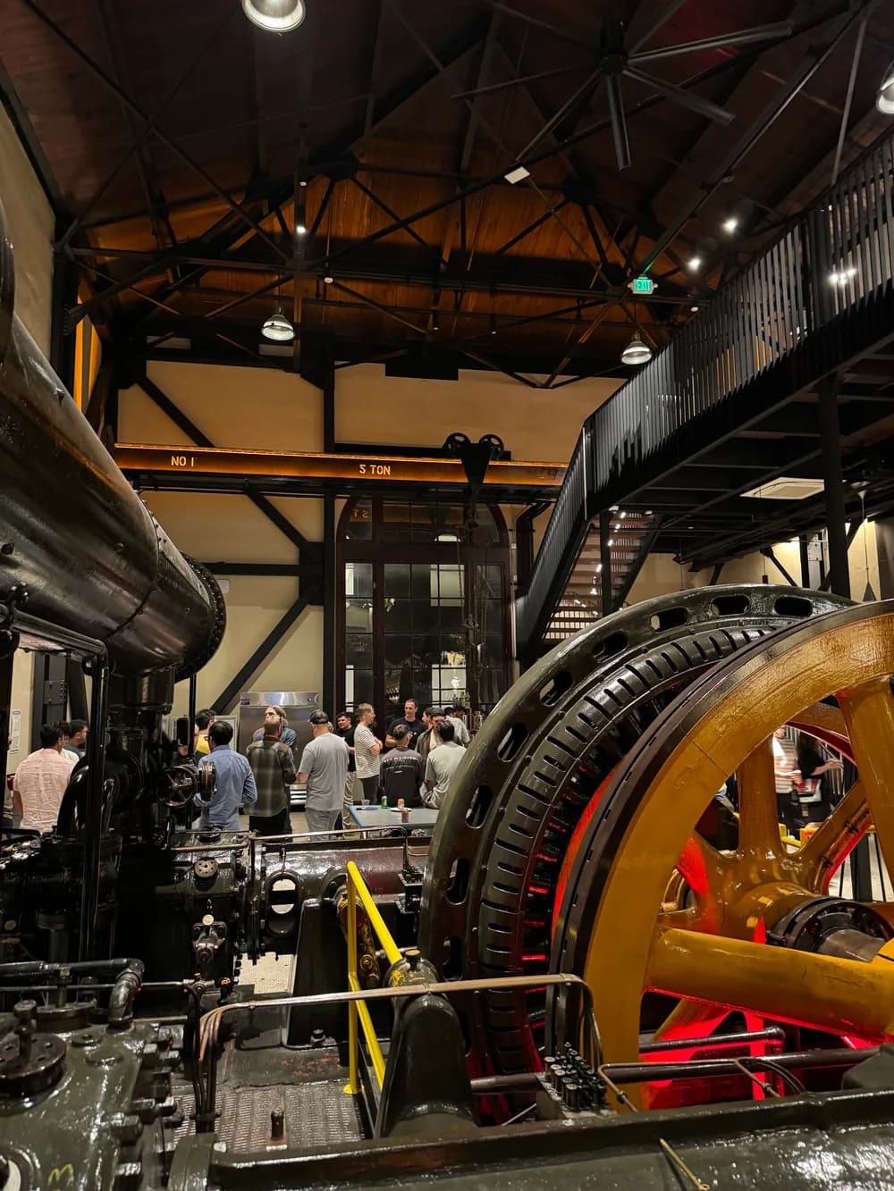 People gathered among large industrial machinery in YC's San Francisco office.